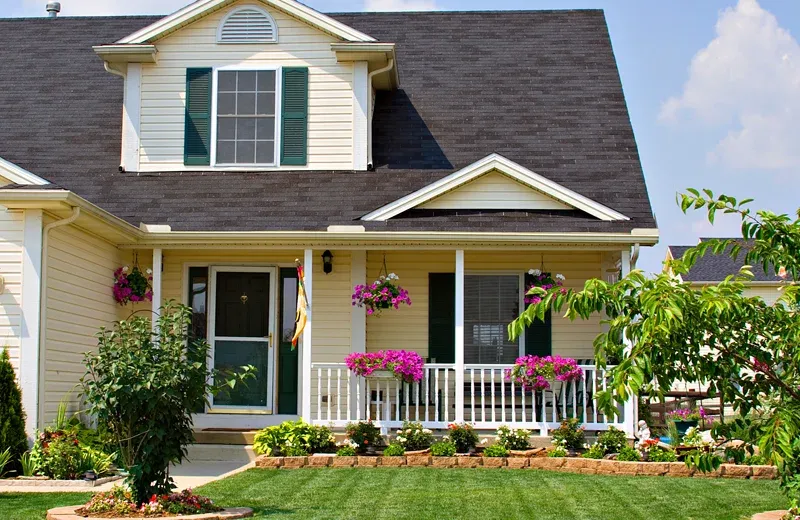 yellow house with nice front porch and green lawn
